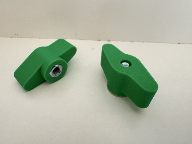 Two green 3D-printed M6 wing nuts with metal inserts